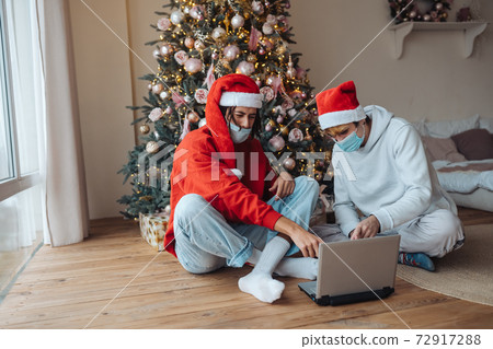 Two friends near the laptop is interacting through video calls. Two friends near the laptop is interacting through video calls. 72917288