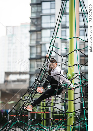 Young woman having fun on the rope pyramid Young woman having fun on the rope pyramid 72917699
