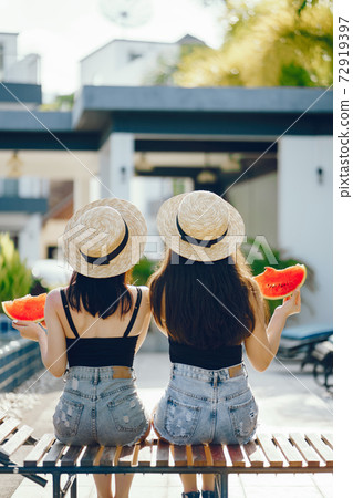 two girls eating watermelon 72919397