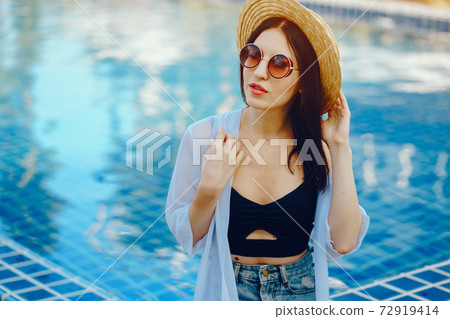 brunette girl relaxing at the pool brunette girl relaxing at the pool 72919414