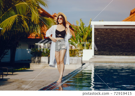 brunette girl relaxing at the pool brunette girl relaxing at the pool 72919415