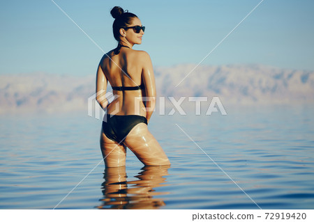 brunette girl swimming in the dead sea brunette girl swimming in the dead sea 72919420