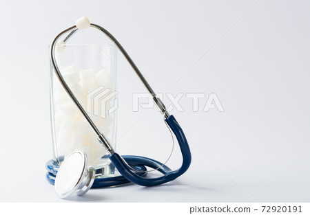 glass full of white sugar cube sweet food ingredient and doctor stethoscope glass full of white sugar cube sweet food ingredient and doctor stethoscope 72920191