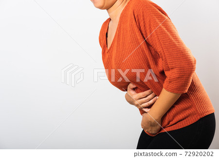 Woman have stomach ache holds hands on abdomen, part of body 72920202