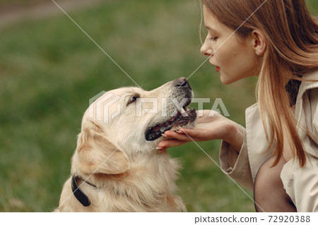 Woman walks in autumn forest with a dog 72920388