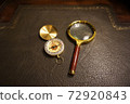 Compass and magnifying glass on the desk 72920843