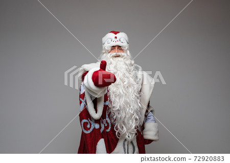 Santa Claus showing thumb up, on gray studio Santa Claus showing thumb up, on gray studio 72920883