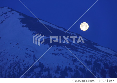 Full moon _ telephoto trying to sink on Mt. Shibutsu where snow accumulates 72921567