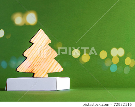 The new year concept as a wooden fir tree on the green with the golden sparkles. 72922116