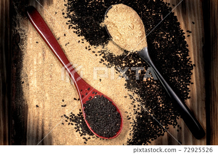 Yin-Yang from black cumin (nigella sativa or kalonji) seeds in spoon and ginger powder on wood background 72925526
