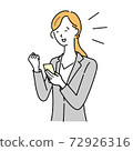 A woman in a suit who is pleased to see her smartphone 72926316