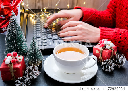Christmas online shopping, work and education. New Year decorations on table. Woman with notebook computer at home. Winter holidays sales 72926634
