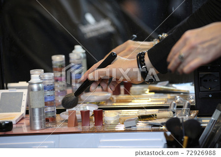 Cosmetologist hand taking brush from a table for make-up Cosmetologist hand taking brush from a table for make-up 72926988