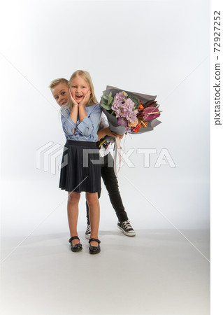 Studio portrait boy gives girl festive bouquet, congratulatory concept, white background, copy space Studio portrait boy gives girl festive bouquet, congratulatory concept, white background, copy space 72927252