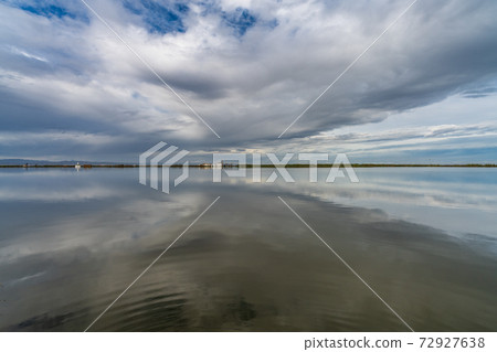 Flooded rice fields under cloudy sky reflection 72927638