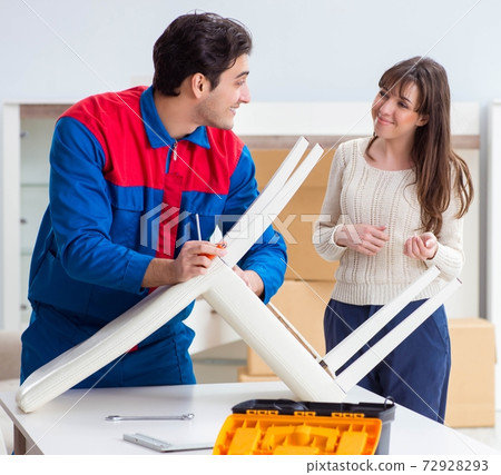 Contractor repairman assembling furniture under woman supervisio Contractor repairman assembling furniture under woman supervisio 72928293