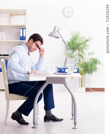 Young handsome businessman employee working in office at desk Young handsome businessman employee working in office at desk 72928294