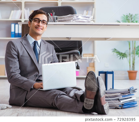 Businessman working and sitting on floor in office Businessman working and sitting on floor in office 72928395