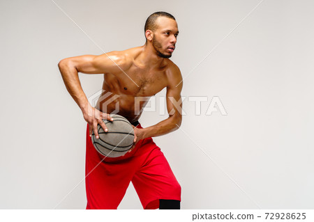 Muscular african american sportsman playing basketball shitless over light grey background 72928625