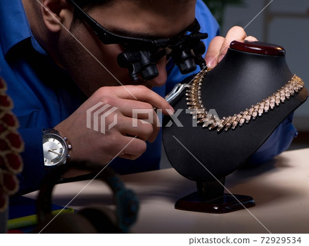 Jeweler working in his workshop late at night 72929534