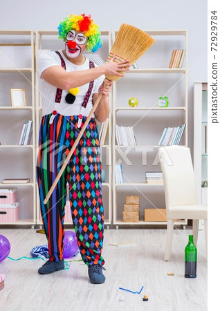 Funny clown doing cleaning at home 72929784