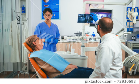 Doctor discussing a plan for denture recovery looking at x ray 72930698