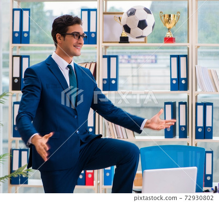 Businessman playing football in the office Businessman playing football in the office 72930802