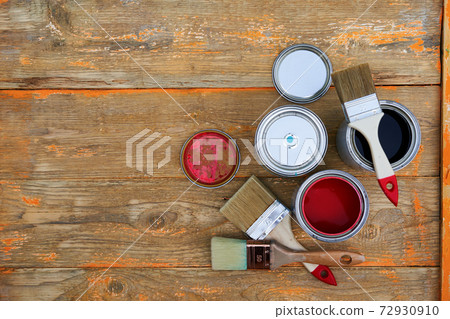 Paint cans and brushes on the old wooden background. Paint cans and brushes on the old wooden background. 72930910