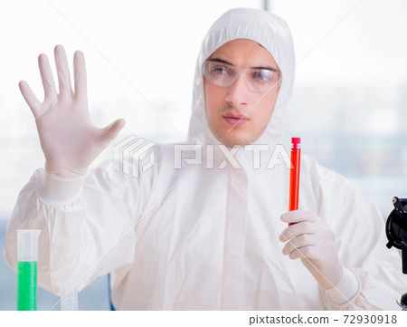 Young chemist pressing virtual buttons in lab Young chemist pressing virtual buttons in lab 72930918