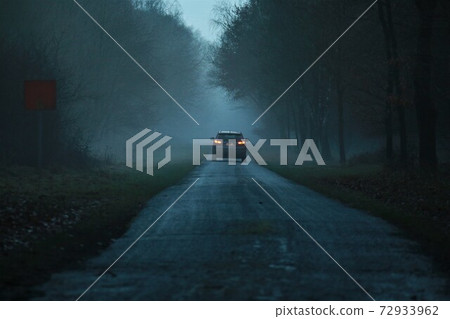 Asphalt road after the rain in the evening in the fog Asphalt road after the rain in the evening in the fog 72933962