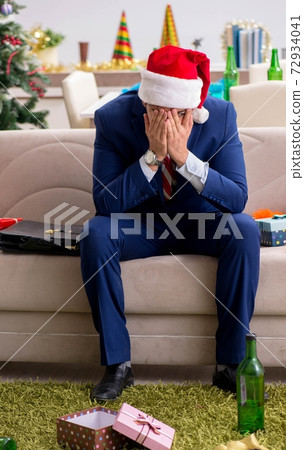 Young handsome employee celebrating Christmas at workplace Young handsome employee celebrating Christmas at workplace 72934041