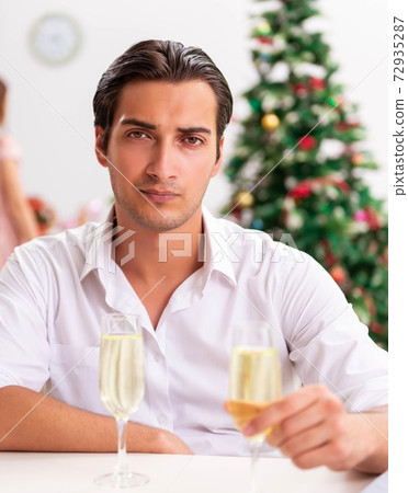 Young sad man christmas with champagne 72935287