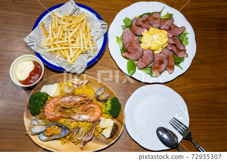 Paella, roast beef and french fries Paella, roast beef and french fries 72935307