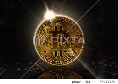 Sunrise behind gold bitcoin standing on financial graphs for cryptocurrency prices Sunrise behind gold bitcoin standing on financial graphs for cryptocurrency prices 72935370