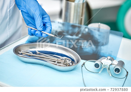 Close-up of dentist's hands and dental equipment 72937880