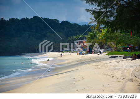 Waves of the azure Andaman sea under the blue sky reaching the shores of the sandy beautiful exotic and stunning Cenang beach in Langkawi island Waves of the azure Andaman sea under the blue sky reaching the shores of the sandy beautiful exotic and stunning Cenang beach in Langkawi island 72939229