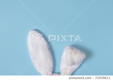 White Fluffy bunny ears isolated on pastel blue background. Creative easter concept White Fluffy bunny ears isolated on pastel blue background. Creative easter concept 72939611