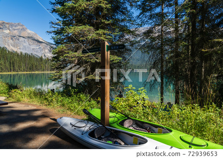 Canoeing on Emerald Lake in summer sunny day. Tourists enjoy leisure water activities on the turquoise color lake in Yoho National Park, Canadian Rockies, British Columbia, Canada. 72939653