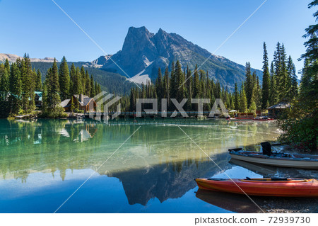 Canoeing on Emerald Lake in summer sunny day. Mount Burgess in the background. Yoho National Park, Canadian Rockies, British Columbia, Canada. Canoeing on Emerald Lake in summer sunny day. Mount Burgess in the background. Yoho National Park, Canadian Rockies, British Columbia, Canada. 72939730