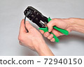 Hands of the installer of computer networks crimped connector on the cable 72940150