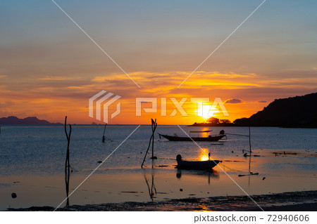 Beautiful sunset on the coast of a tropical island in Thailand, a silhouette of a boat in the ocean 72940606