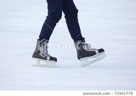 Legs of a man skating on an ice rink. Hobbies and sports. Vacations and winter activities 72942779