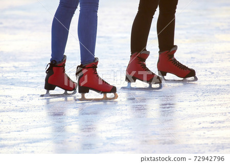 feet in red skates on an ice rink. hobbies and leisure. winter sports feet in red skates on an ice rink. hobbies and leisure. winter sports 72942796