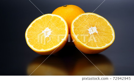 Citrus fruit. Cut and whole orange on dark background 72942945