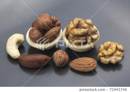Different types of nuts in a waffle cone on a gray background. Healthy and protein food Different types of nuts in a waffle cone on a gray background. Healthy and protein food 72943746