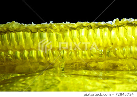 comb honey glows on a black background 72943754