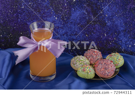 Colorful set of sweet small doughnuts with a glass jar of juice Colorful set of sweet small doughnuts with a glass jar of juice 72944311