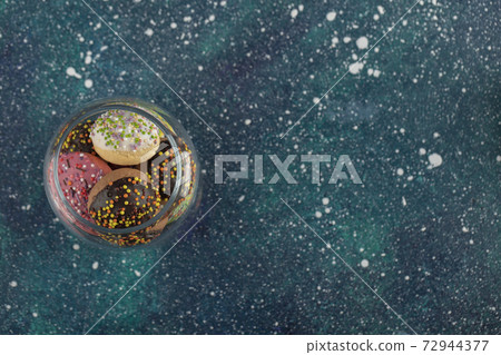 A glass jar full of small colorful doughnuts A glass jar full of small colorful doughnuts 72944377