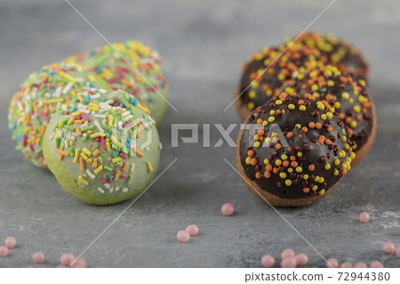 Colorful sweet chocolate small doughnuts with sprinkles Colorful sweet chocolate small doughnuts with sprinkles 72944380
