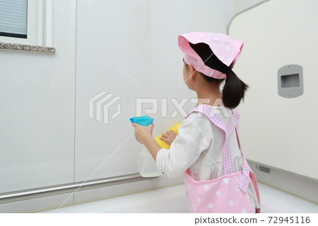 A 5-year-old girl helping to clean the bath A 5-year-old girl helping to clean the bath 72945116
